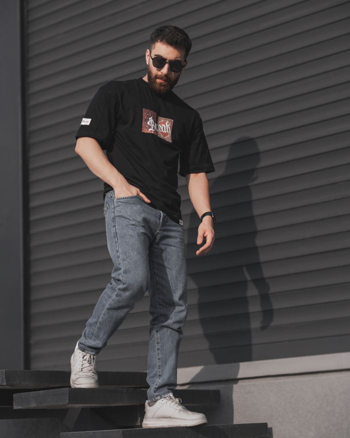 Young man in sunglasses and casual attire poses in urban setting. Perfect for street style and fashion photography.
