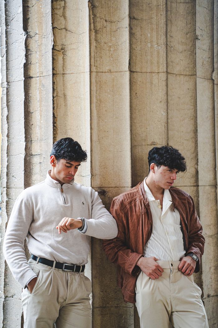 Two fashionable men in Munich showcasing classic autumn urban style.
